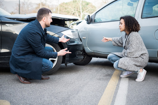 Man and young woman arguing after bad car crash